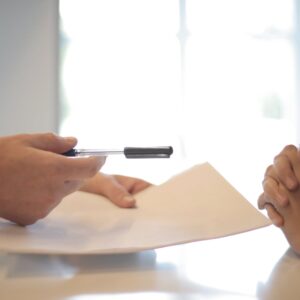 Crop businessman giving contract to woman to sign